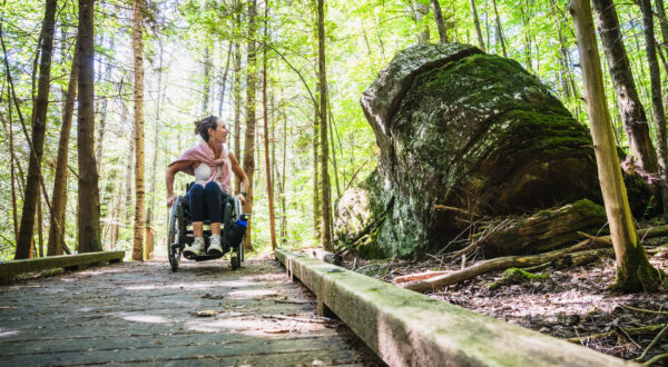 woman in wheelchair enjoying VT forest along accessible trail