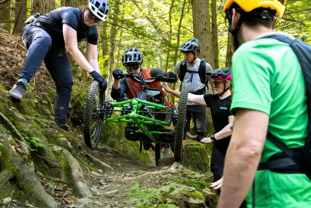 mountain biker receiving assistance on challenging trail