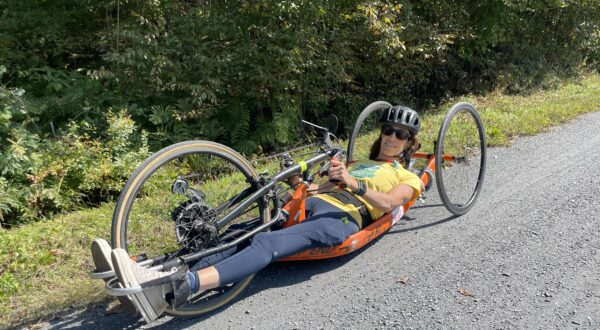 Lamoille valley rail trail flat hard stone trail in woods person in handcycle
