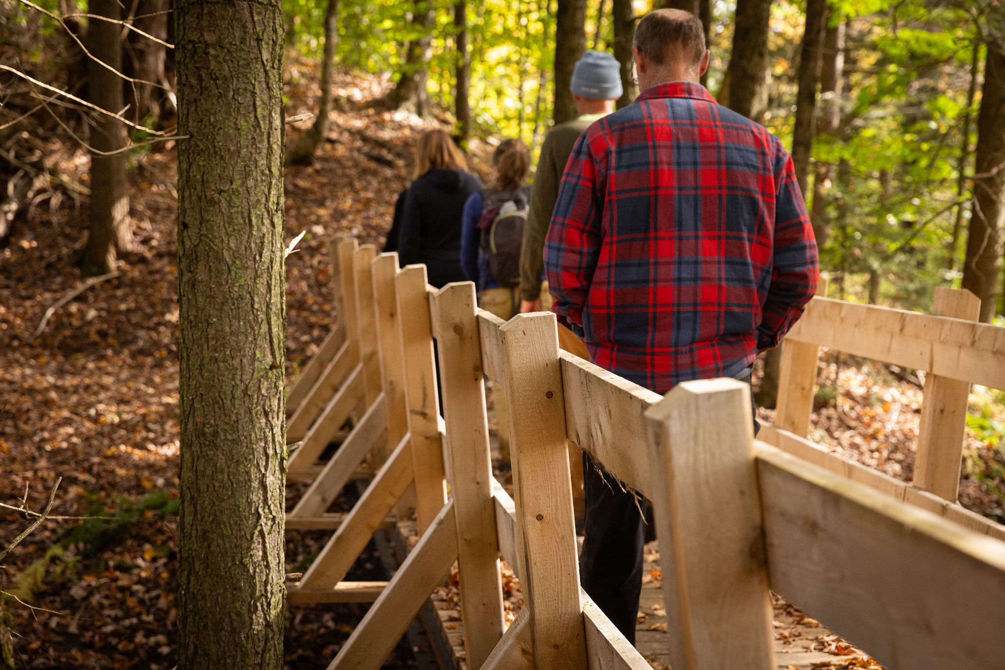 four people walking across bridge