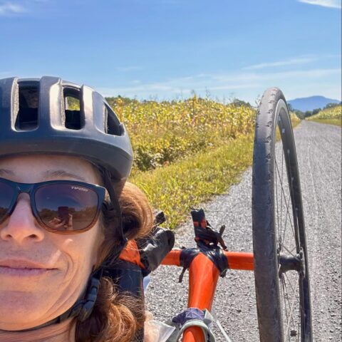 Lamoille valley rail trail flat hard stone selfie of edie perkins in a handcycle with mountains in background